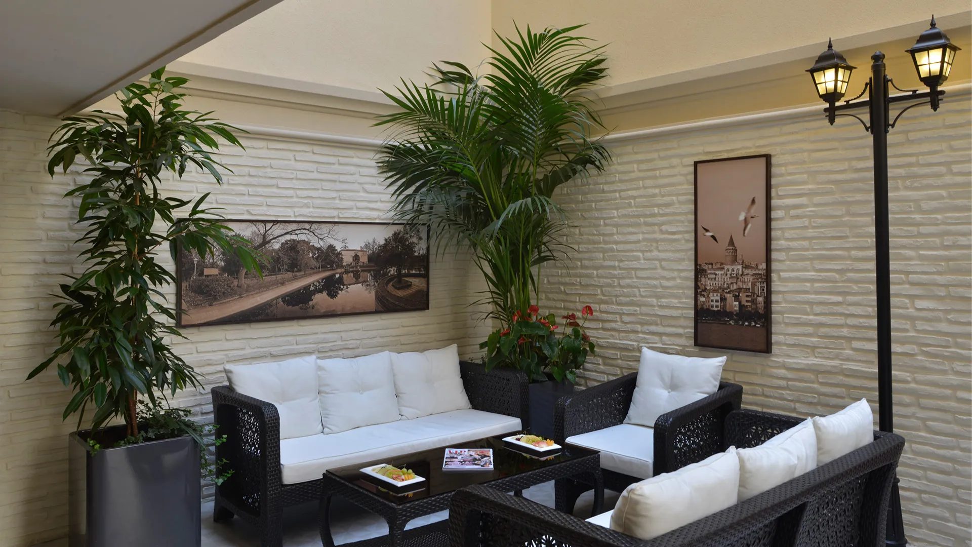 Garden Cafe: tuğla duvar, palmiyeler ve fener